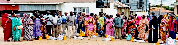 A long line of men and women with food & oil waiting for further assistance.